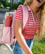 Klean Kanteen Rise Insulated Classic Bottle with Flip Seal Cap in limited edition Cayenne colourway in a woman's backpack bottle pocket. 