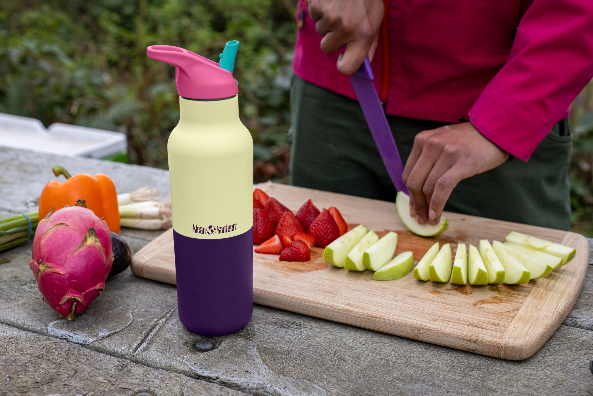 Klean Kanteen Rise Insulated Classic Bottle with Flip Seal Cap in limited edition Wax Yellow on an outdoor picnic table. 