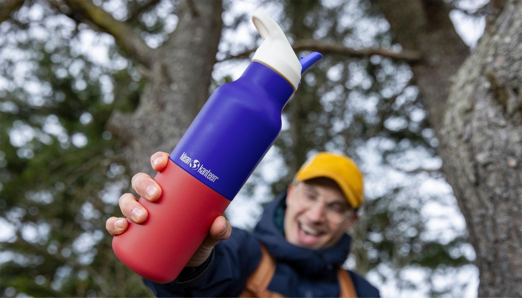 Man holding Klean Kanteen Rise Insulated Classic Bottle with Flip Seal Cap in limited edition Dazzling Blue colourway.