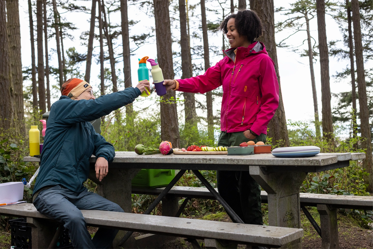 Hikers using Klean Kanteen Rise Insulated Classic Bottles on a picnic in the forest.