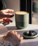 A klean Kanteen sea spray lowball tumbler next to the rise slide lid showing the silicone ring around the cap
