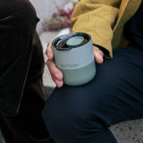 Man holding a Klean Kanteen sea spray green lowball rumbler with the rise slide lid on top and fully closed