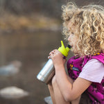 Girl drinking from a stainless steel kids Klean Kanteen bottle with a green sports drink cap 