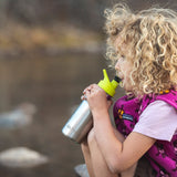 Girl drinking from a stainless steel kids Klean Kanteen bottle with a green sports drink cap 