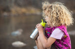 Girl drinking from a stainless steel kids Klean Kanteen bottle with a green sports drink cap 