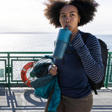 A woman sipping the straw on the brittany blue coloured 26oz Klean Kanteen rise tumbler. 