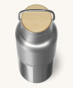 A close up of the Klean Kanteen 16oz reusable stainless steel reflect water bottle available at Babipur showing the bamboo detail on top of the loop cap. 