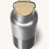 A close up of the Klean Kanteen 16oz reusable stainless steel reflect insulated bottle available at Babipur showing the bamboo detail on top of the loop cap. 