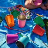 Six colours of Klean Kanteen 10oz/296ml Steel Kid Cups with Straw Lids taken off and straws taken out placed on a blue blanket.