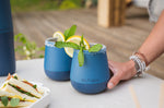 Close up of a hand holding a Klean Kanteen blue insulated wine tumbler