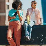 Adult holding a wax yellow Klean Kanteen 20oz insulated bottle with matching lid next to an adult holding a black bottle