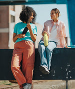 Adult holding a wax yellow Klean Kanteen 20oz insulated bottle with matching lid next to an adult holding a black bottle
