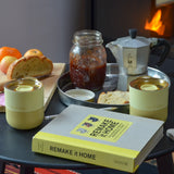 2 Klean Kanteen stainless 8oz tumblers in wax yellow with their lids on top standing on a wooden table with breakfast items 