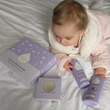 A baby lying on a bed and holdong the kokoso coconut oil baby lotion and body wash from the coconut bathtime set available at Babipur.