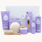 Kokoso Scented Baby Collection - Coconut & Lavender, showing the contents of the Collection. Cocont Oil, Baby Soft Balm Stick, Gentle Hair & Body Wash, Coconut Oil Baby Lotion, Natural Brush, and a Sponge. The items are displayed on a cream background