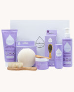 Kokoso Scented Baby Collection - Coconut & Lavender, showing the contents of the Collection. Cocont Oil, Baby Soft Balm Stick, Gentle Hair & Body Wash, Coconut Oil Baby Lotion, Natural Brush, and a Sponge. The items are displayed on a cream background