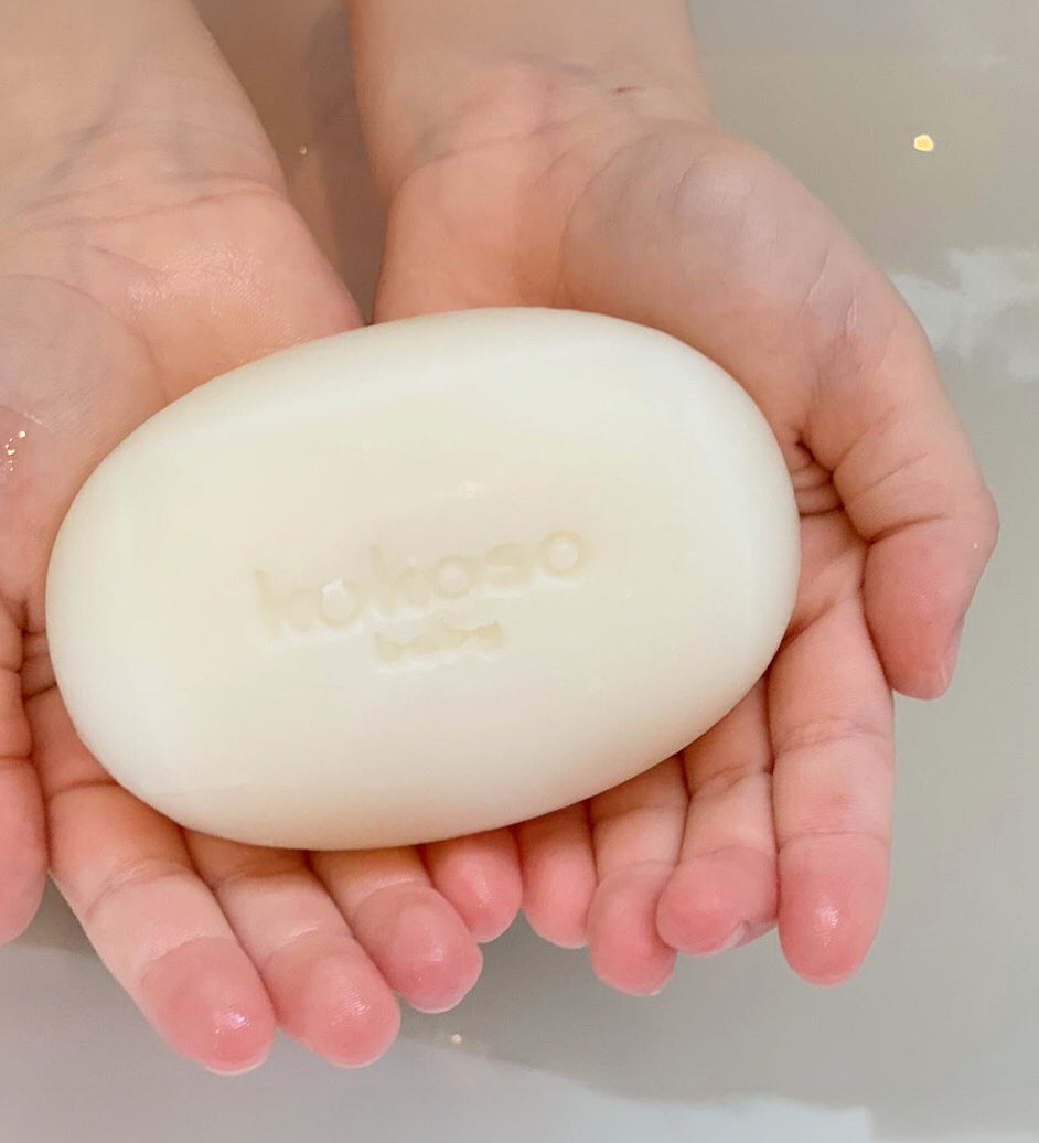 A close up of a child holding the Kokoso Organic Baby Soap available at Babipur. 