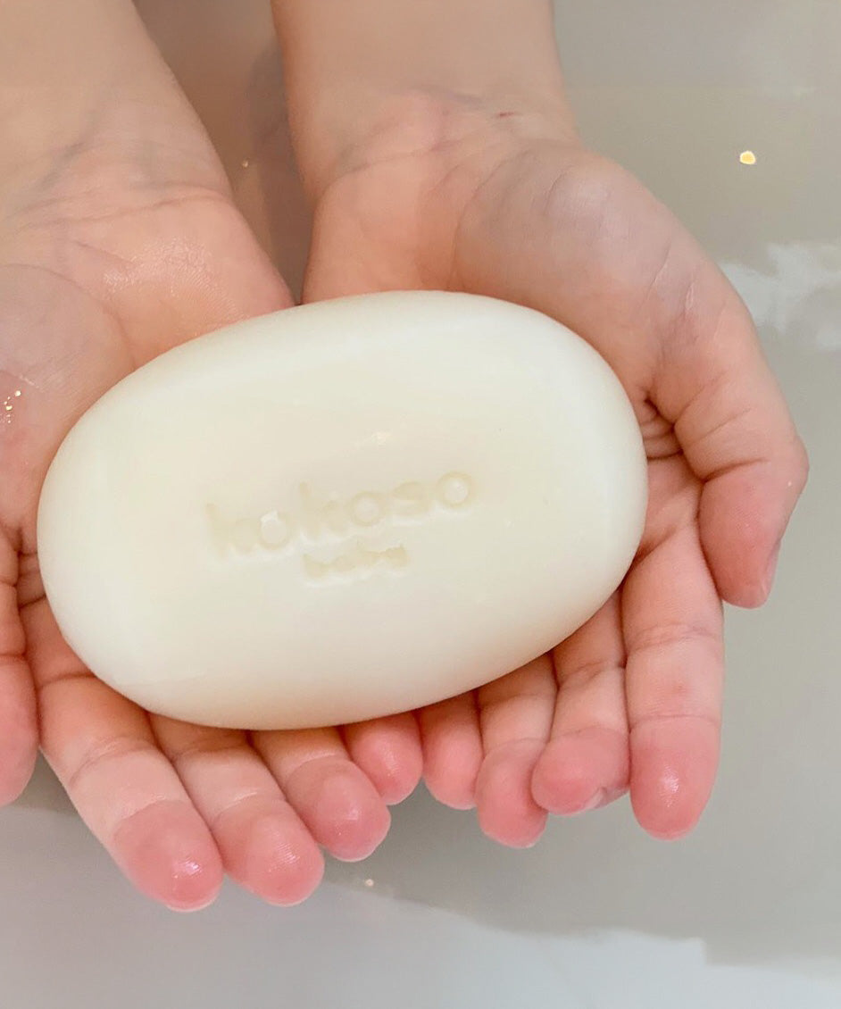 A close up of a child holding the Kokoso Organic Baby Soap available at Babipur. 