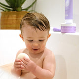 A baby in the bath and holding the Kokoso konjac sponge available at Babipur.