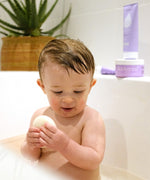 A baby in the bath and holding the Kokoso konjac sponge available at Babipur.