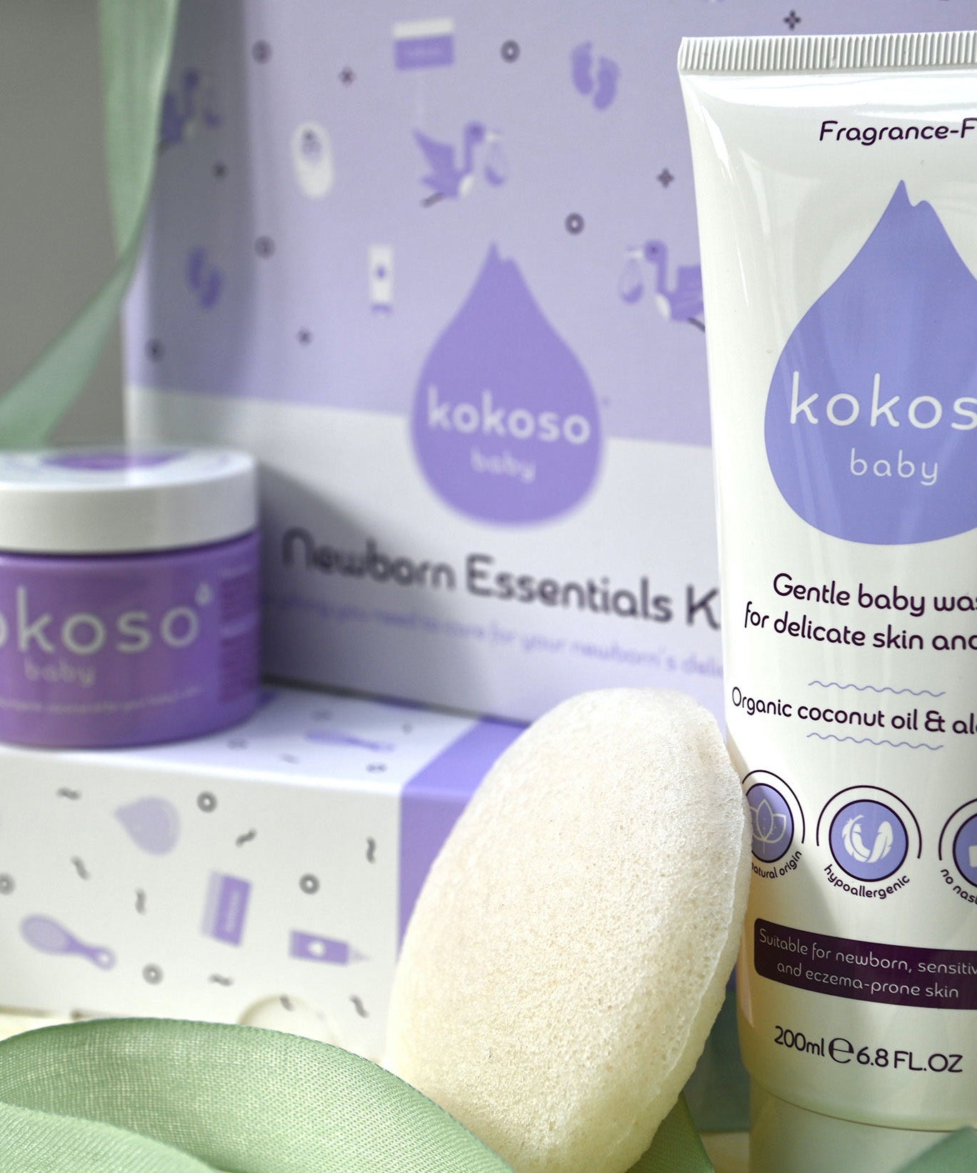 A close up of the contents included with the Kokoso newborn essentials kit showing the Kokoso Organic Coconut Oil, the Kokoso Gentle Hair & Body Wash and a Kokoso 100% Natural Konjac Baby Bath Sponge