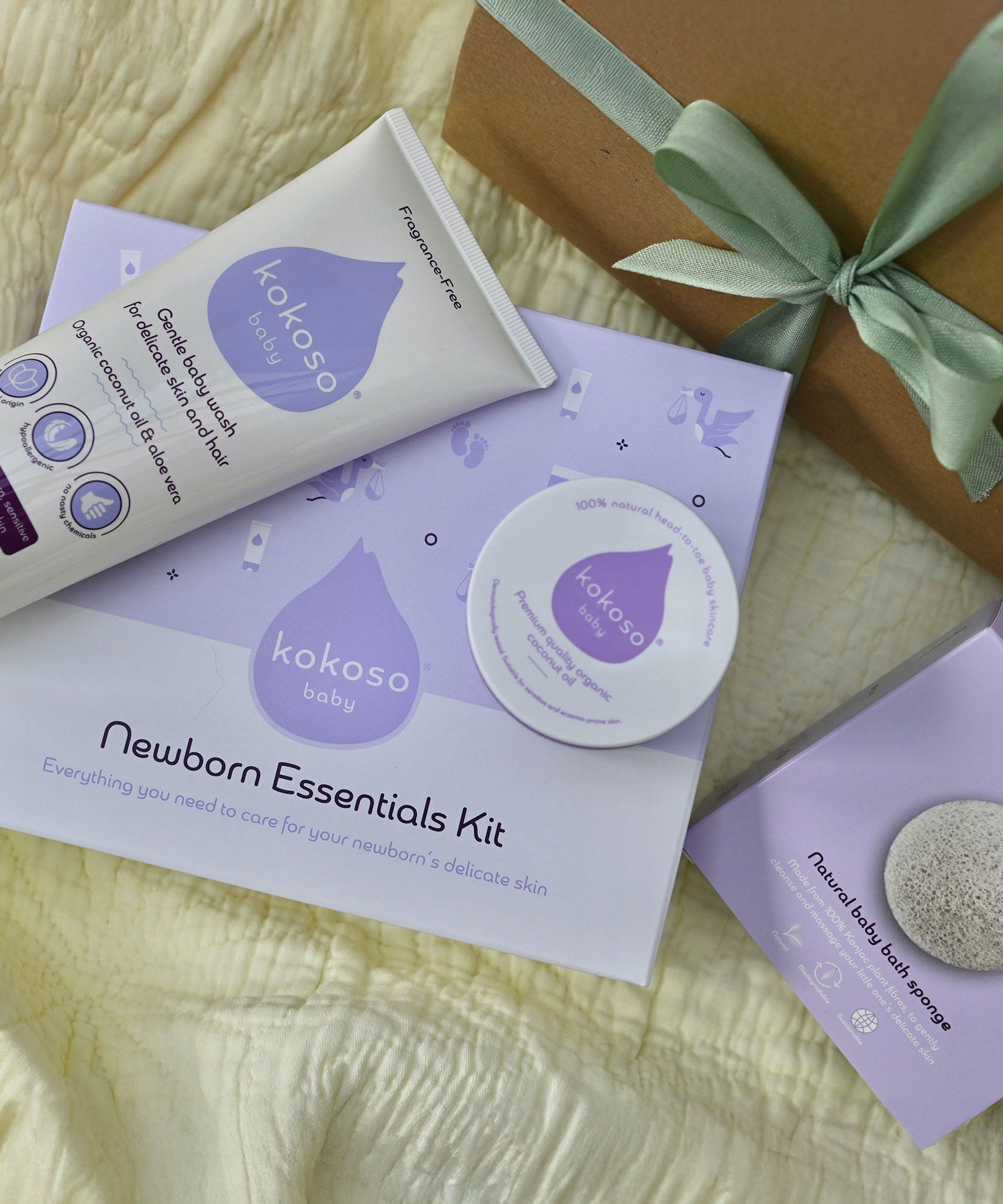 A top down image of the contents on included with the Kokoso newborn essentials kit showing the Kokoso Organic Coconut Oil, the Kokoso Gentle Hair & Body Wash and a Kokoso 100% Natural Konjac Baby Bath Sponge. Newborn essentials kit available at Babipur.