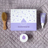A top down image of the products included with the sensitive gift set next to the packaging showing the scalp cream, natural baby brush and and organic coconut oil available at Babipur.