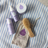 A collection of Kokoso baby crae items including the Happy Scalp Cream in a 50ml container, small tub of organic coconut oil, hairbrush and baby soft balm stick. The Kokoso baby care range is available at Babipur.