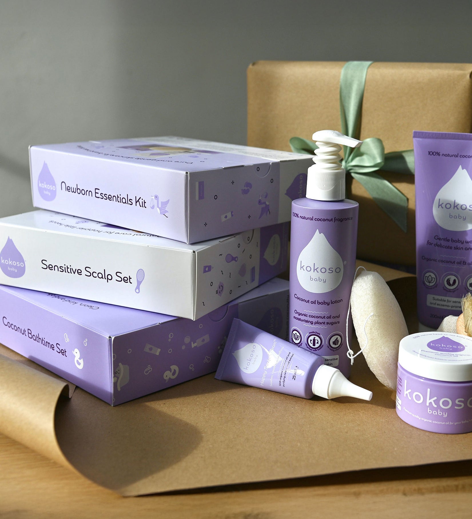 A range of Kokoso gift sets on a table ready to be wrapped. Showing the newborn essentials kit, sensitive scalp set and coconut bathtime set all available at Babipur.