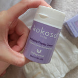 A close up of an adult hand holding the  tube of Kokoso organic coconut oil Happy Nappy Cream showing the size of the tube available at Babipur