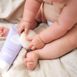 Chubby baby sits on sheet