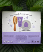 The back of the The Sensitive Scalp Set box with a tropical leaves in the background, includes Scalp Cream, Natural Baby Brush and and organic Coconut oil available at Babipur.