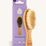 The Kokoso Natural Baby Hairbrush available at Babipur standing next to it's purple branded packaging. Features a wooden handle and soft natural bristles