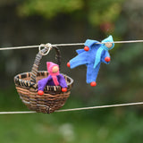 Blue and purple felt Kraul Little Passenger Dolls placed on the Kraul cable car kit. One is holding onto the string and the other is placed in the basket.