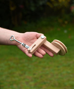 An adult's hand holding the clamp that they have assembled from the  Kraul DIY Basket Cable Car STEM Kit in their hand.