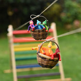 Two wicker baskets filled with felt passengers travelling along the string from the Kraul DIY Basket Cable Car STEM Kit.