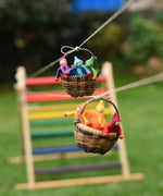 Two wicker baskets filled with felt passengers travelling along the string from the Kraul DIY Basket Cable Car STEM Kit.