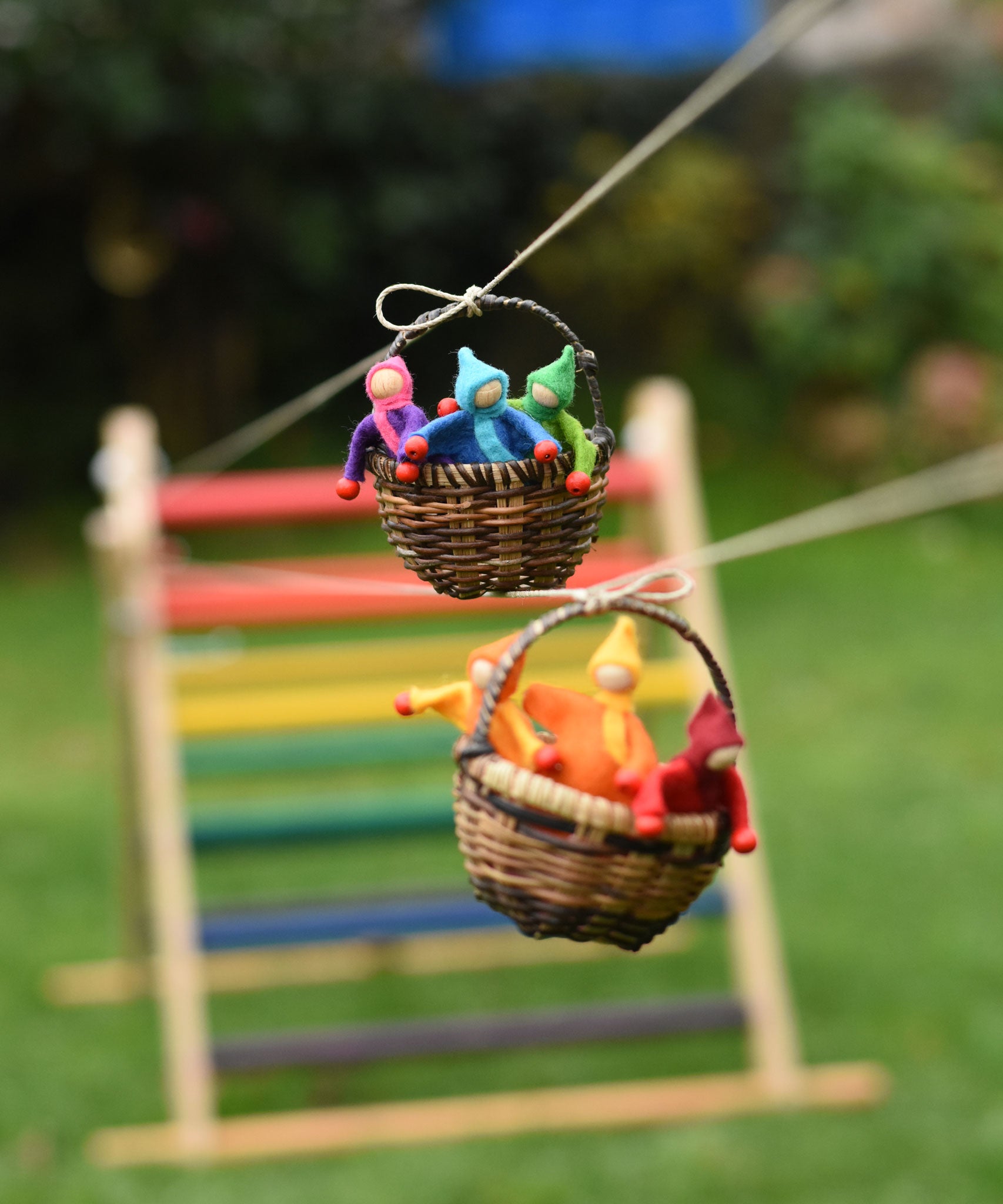 Two wicker baskets filled with felt passengers travelling along the string from the Kraul DIY Basket Cable Car STEM Kit.