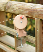 The clamp from the Kraul DIY Basket Cable Car STEM Kit attached to a mud kitchen outdoors.