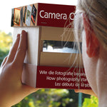 A child holding and looking through the Kraul build your own wooden camera obscura kit