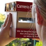 A child holding and looking through the Kraul build your own wooden camera obscura kit