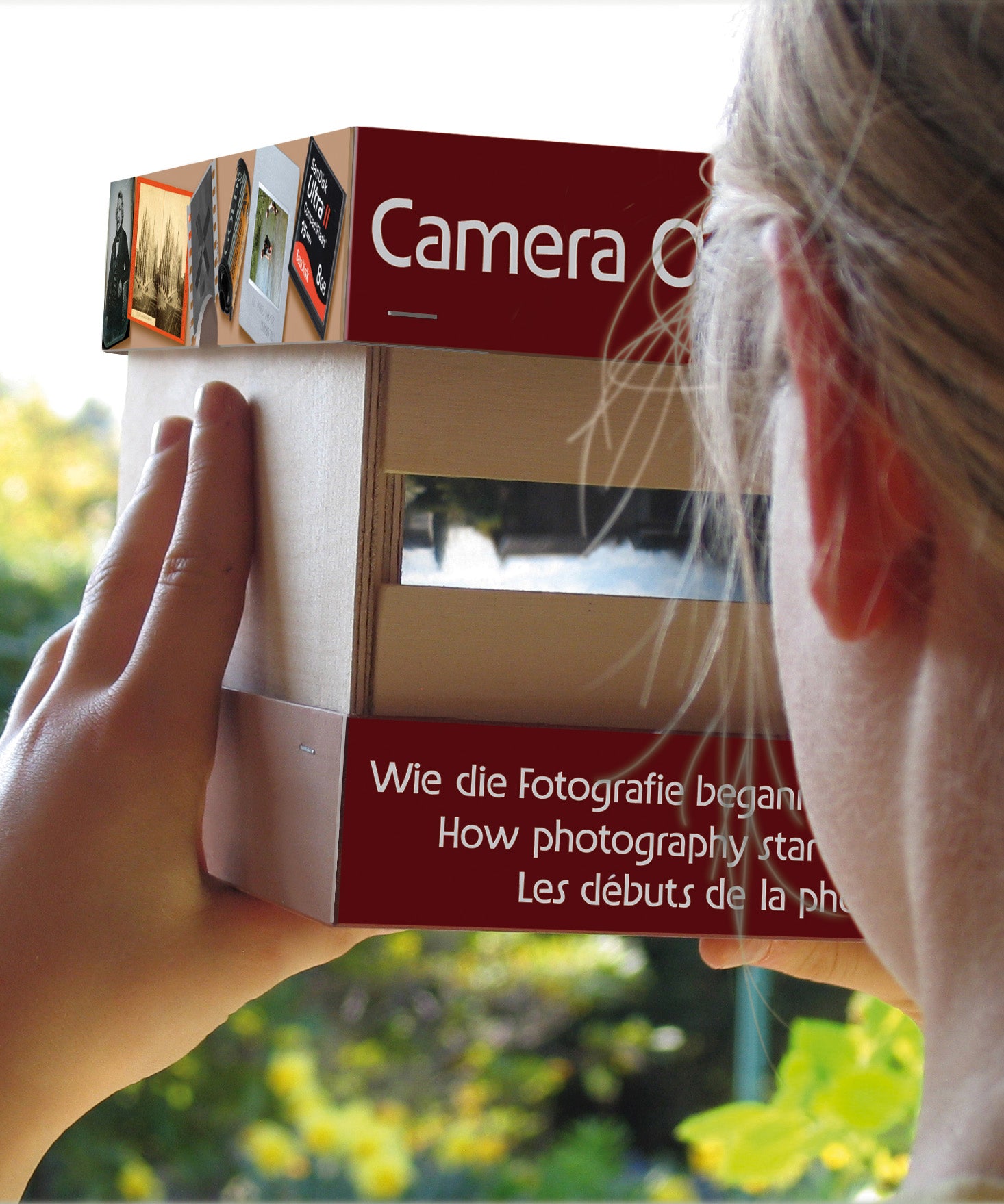 A child holding and looking through the Kraul build your own wooden camera obscura kit