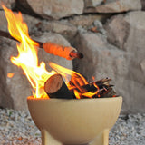 A fire lit in the Kraul ceramic fire bowl filled with logs and sticks. Kraul is available at Babipur their range of kits let children discover a world of wonder with Kraul STEM science kits and educational toys.