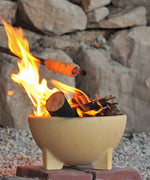 A fire lit in the Kraul ceramic fire bowl filled with logs and sticks. Kraul is available at Babipur their range of kits let children discover a world of wonder with Kraul STEM science kits and educational toys.