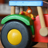A Kraul felt passenger pose-able doll placed in the cab of the Bajo wooden tractor toy. These pose-able dolls are perfect to fit inside smaller toy vehicles and for use with the Kraul cable cars.