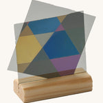 Close up view of the mirrors on a wooden stand from the Kraul lights and colour kit creating different coloured prism shapes 