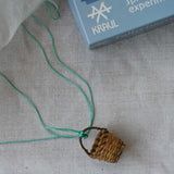 The basket from the Kraul parachute kit tied with the thread onto the silk paper paprachute. The kit contains papers, thread and a mini basket. Kraul offers a range of thoughtful science toys that bring natural forces to life through real-world exploration and play.