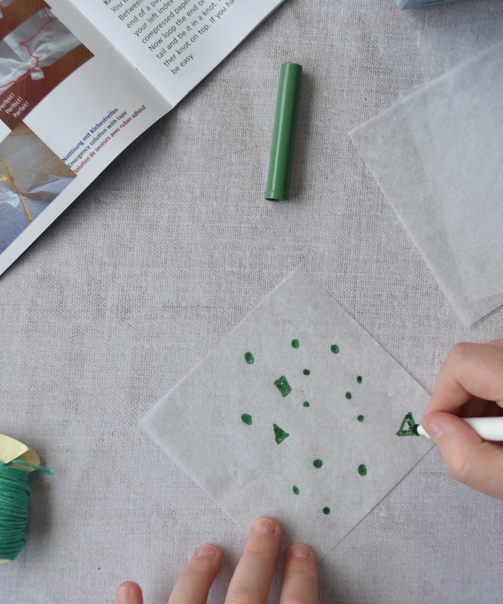 A close up of a child's hand decorating the silk paper squares with felt tip. The kit contains papers, thread and a mini basket. Kraul offers a range of thoughtful science toys that bring natural forces to life through real-world exploration and play.