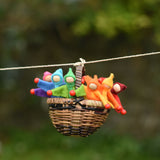 A collection of felt Kraul Little Passenger Dolls placed in a Kraul cable car basket