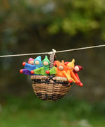 A collection of felt Kraul Little Passenger Dolls placed in a Kraul cable car basket